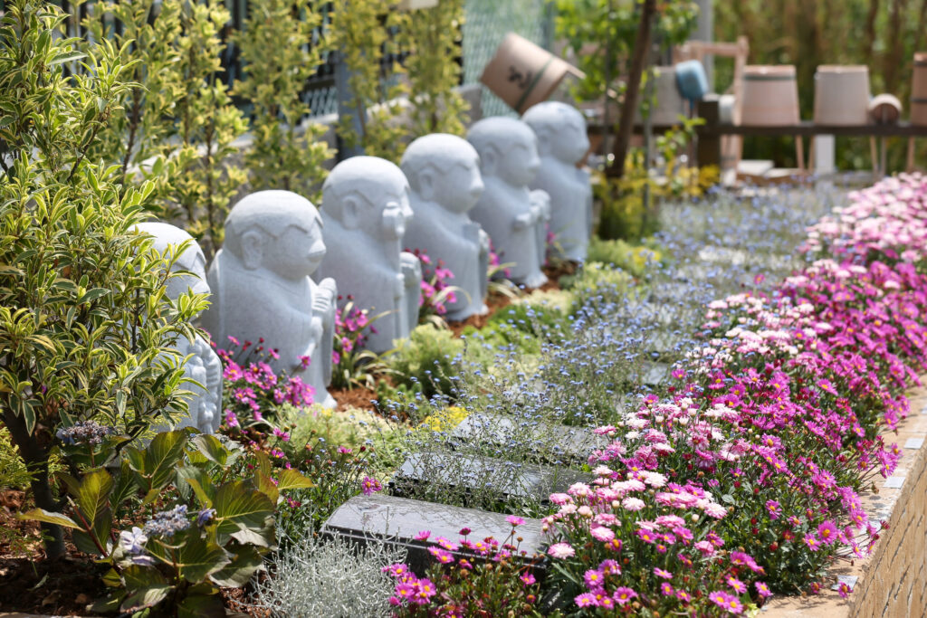 小牧はなえみ墓園 永代供養エリア｜六地蔵様の列とピンクの花畑（合祀後永代供養の象徴）