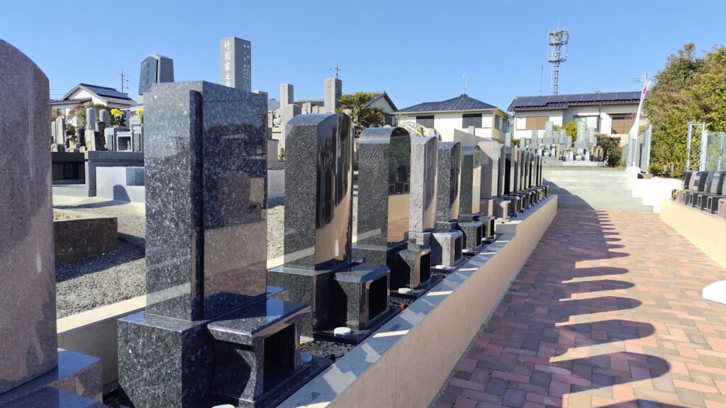 豊橋高師はなえみ墓園｜手前に新規洋型墓石区画・背景に「竹園家」「伊藤家」「板坂家」など既存檀家墓・赤レンガ敷き参道