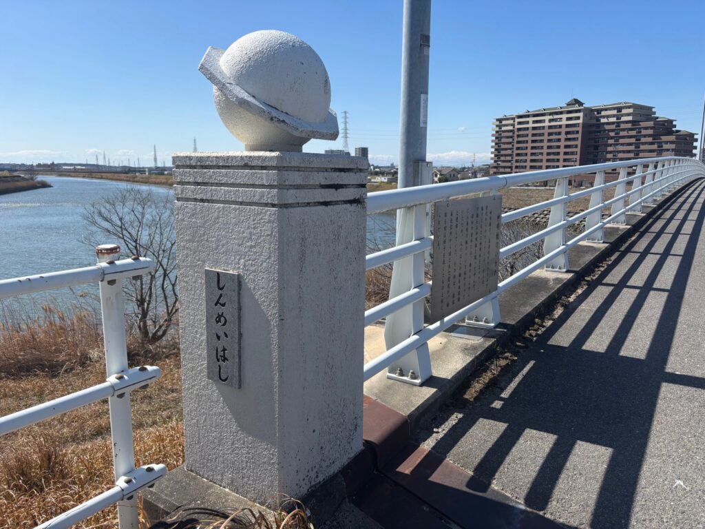 神明橋（しんめいはし）の親柱と橋銘板｜「しんめいはし」と刻まれた白いコンクリートの親柱 刈谷はなえみ樹木葬（龍江寺）から車で約1分