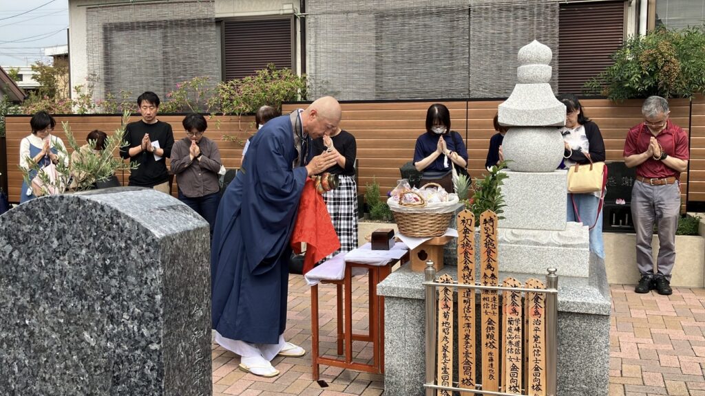 春秋彼岸の「はなえみ祭り」合同供養｜曹洞宗 本覚寺 尾頭彰彦住職による施食会・ご利用者様が合掌する永代供養塔前の法要風景