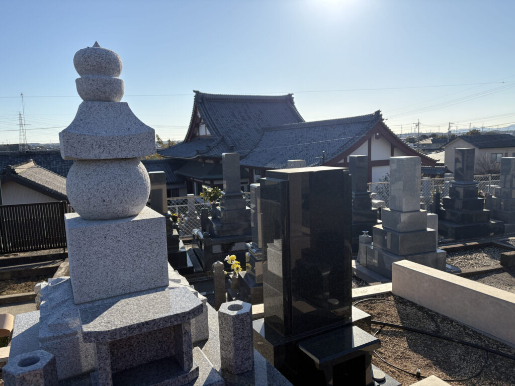 豊橋高師はなえみ墓園の朝日参道｜温かみのある赤レンガ敷き・両脇に整然と並ぶ洋型墓石・正面奥に五輪塔・澄み切った青空