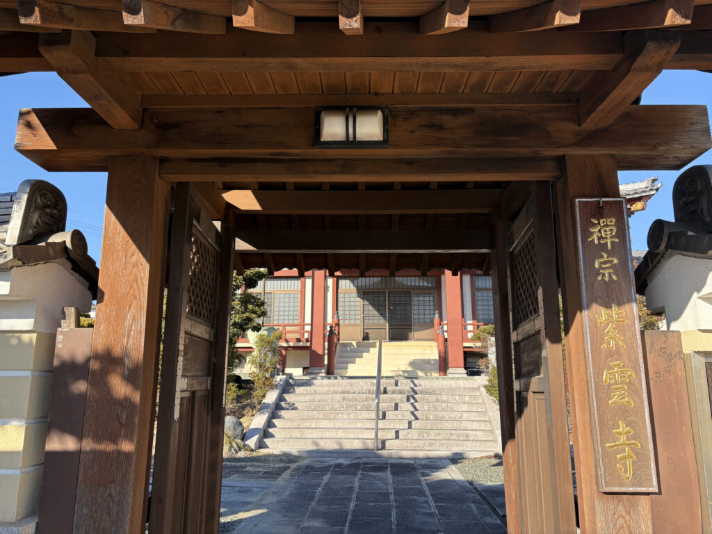 紫雲寺の山門｜「禅宗 紫雲寺」と金箔文字で刻まれた木製看板・朱色柱の本堂が見える（豊橋市高師本郷町）