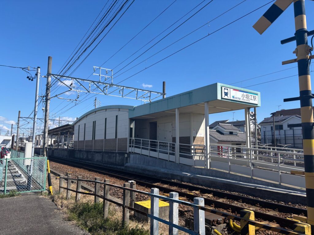 名鉄三河線 小垣江駅（MEITETSU OGAKE STATION）外観｜緑地の駅名看板と単線の線路 龍江寺 刈谷はなえみ樹木葬から車で約5分
