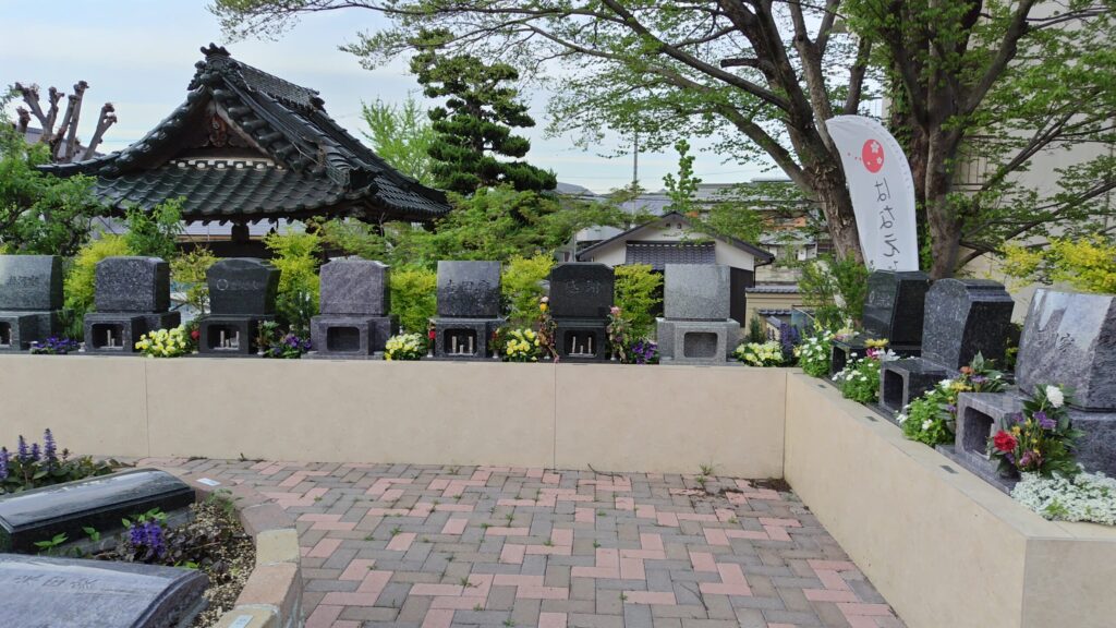 岡崎美合はなえみ墓園 実景｜建立済み墓石が並ぶ全景｜西福寺本堂の屋根と新緑の桜