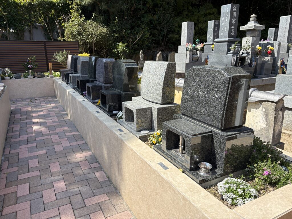 西尾吉良はなえみ墓園 洋型墓石区画02-07 黒・青影・グレー・ピンク・茶系御影石の整列 既存の坂田家・林家墓地が背景