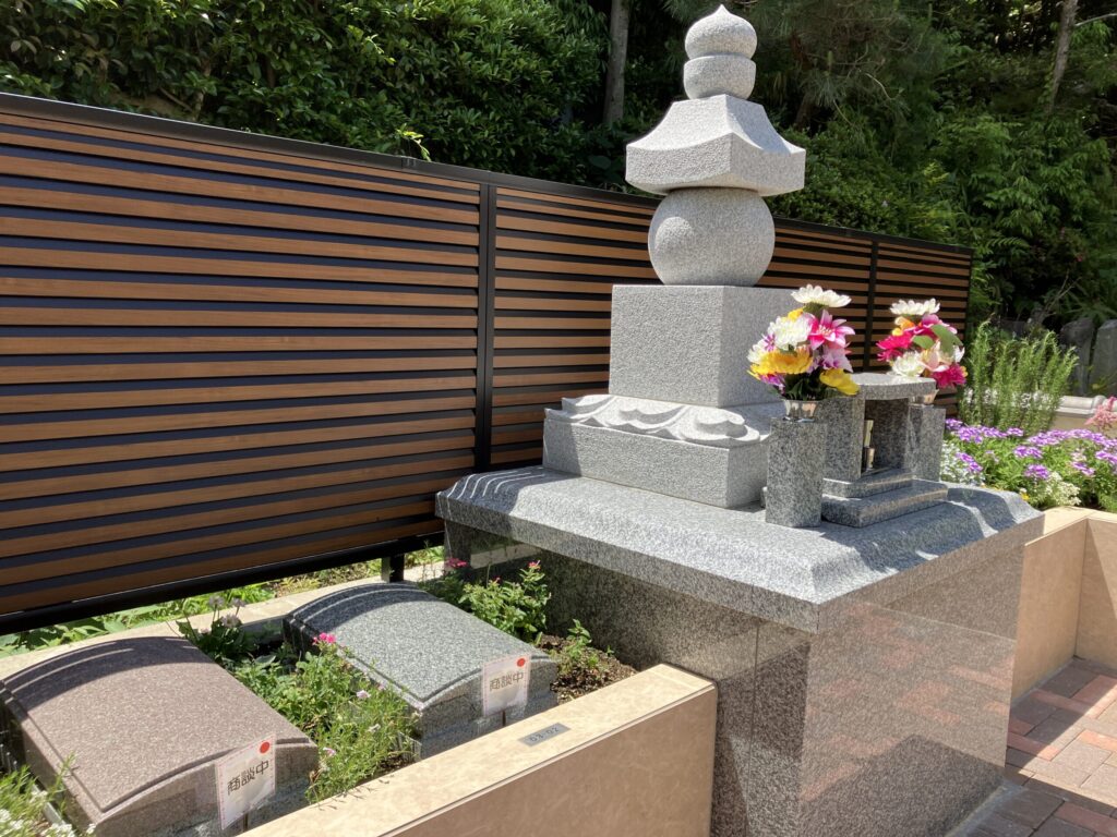 西尾吉良はなえみ墓園 白御影石の本格五輪塔 永代供養塔 地・水・火・風・空の五層構造 鮮やかな生花 「商談中」赤シール付き板型墓石 紫アリッサム