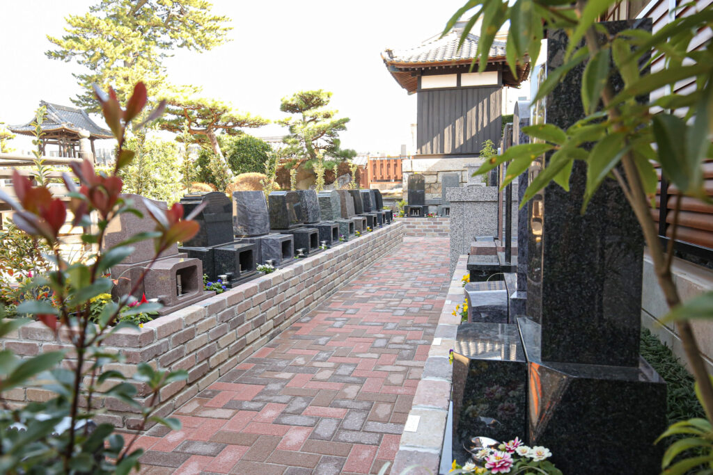 レンガ参道沿いに並ぶ墓石と鐘楼｜岡崎はなえみ墓園