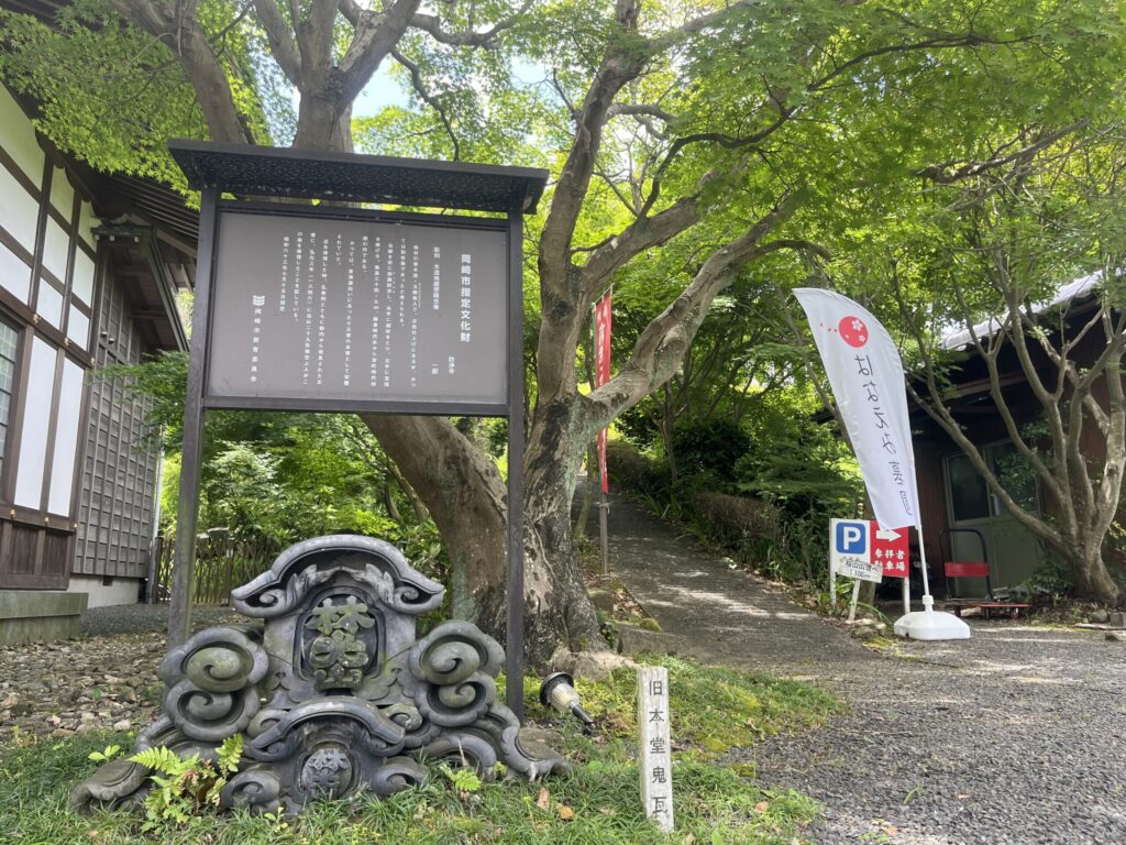 岡崎市指定文化財「木造地蔵菩薩坐像」を記す欣浄寺の案内看板と旧本堂の鬼瓦