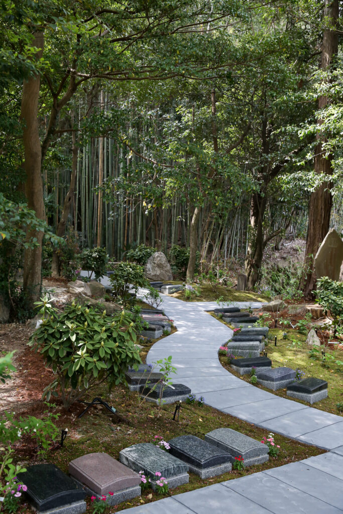 竹林の中を緩やかにカーブする石畳と板型墓石（阿久比はなえみ墓園の樹木葬）