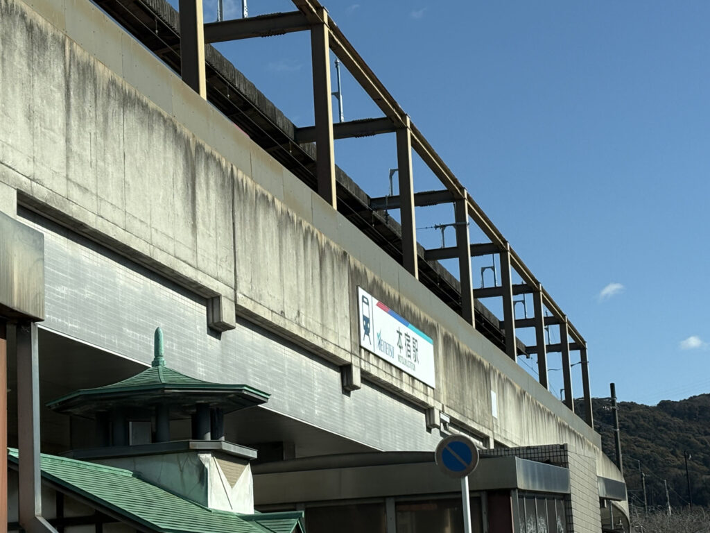 名鉄名古屋本線の高架駅・本宿駅の駅舎と駅名標